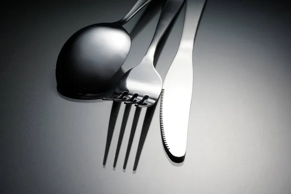 silverware, stainless fork, knife and spoon on grey surface