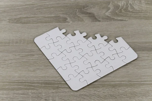 jigsaw puzzle pieces on wooden floor surface