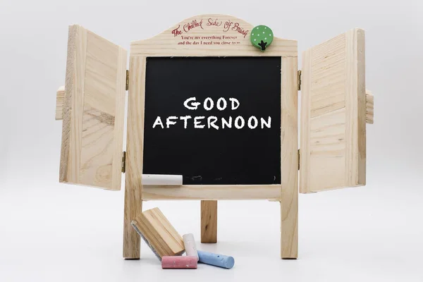 wooden blackboard with chalks and written text good afternoon