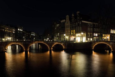 Kanallı ve binalı Amsterdam şehrinin gece manzarası