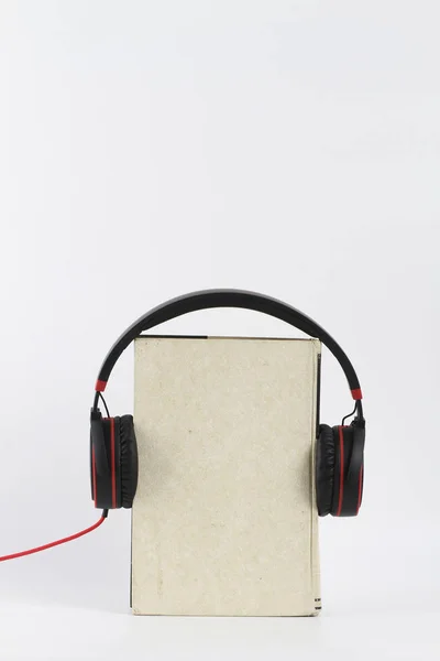 Koptelefoon en een boek — Stockfoto
