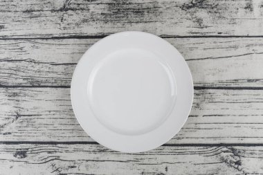 Ahşap masanın üzerinde boş bir tabak. 