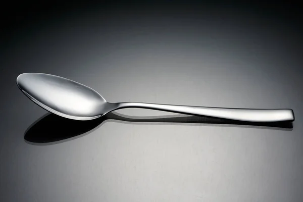 silver spoon on surface,