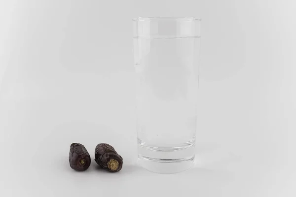 Ποτήρι Νερό Και Αποξηραμένες Ημερομηνίες Λευκό Φόντο — Φωτογραφία Αρχείου