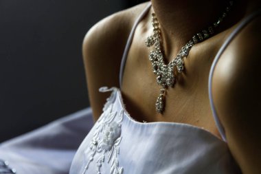 Gelinin kolye taktığı manzara ve güzel beyaz elbise.