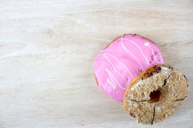 Tahta yüzeyde çeşitli donutların düz yatışı.