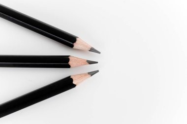 Stüdyoda beyaz arka planda tahtadan siyah kalemler