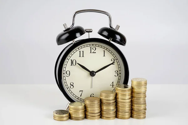 金融マネーコインとアナログヴィンテージ目覚まし時計 ロイヤリティフリーのストック写真