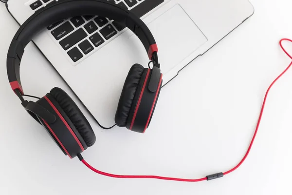 Zenét Hallgatni Fejhallgatón Keresztül Egy Laptopon Dolgozni Fehér Asztalon Stock Fotó