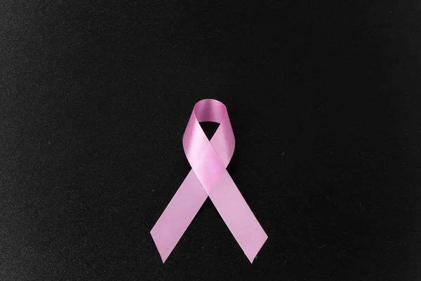 pink aids ribbon on black background
