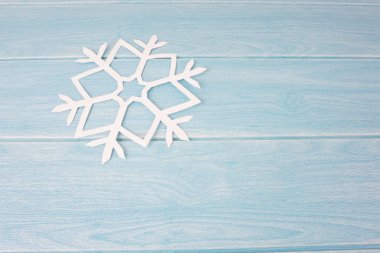 mavi ahşap masa yüzeyinde origami kağıt kar tanesi, üst görünüm 