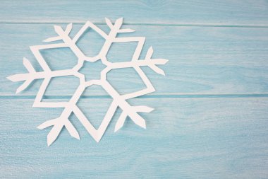 mavi ahşap masa yüzeyinde origami kağıt kar tanesi, üst görünüm 