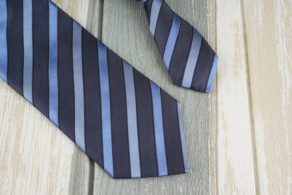 dark blue striped neck tie on wooden surface