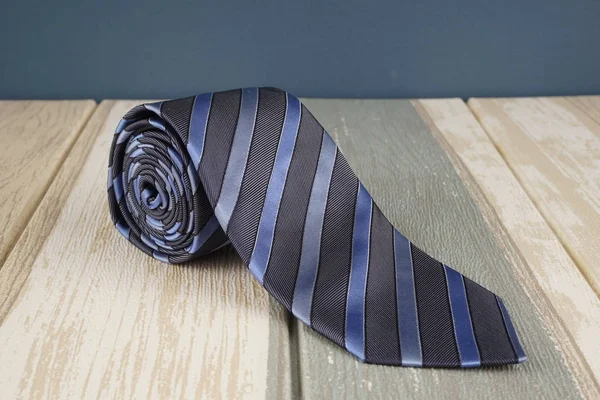 dark blue striped neck tie on wooden surface