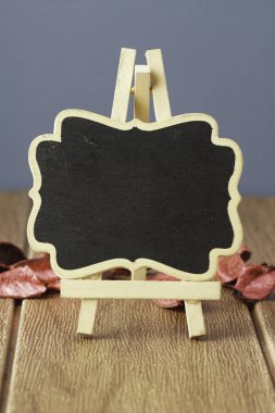 Sonbahar kuru yapraklı ahşap masa üzerinde küçük karatahta, boşluk konseptini kopyala