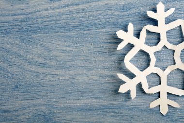 kısmi görünüm, mavi ahşap masa yüzeyinde origami kağıt kar tanesi kırpılmış parçası 