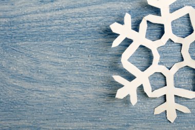 kısmi görünüm, mavi ahşap masa yüzeyinde origami kağıt kar tanesi kırpılmış parçası 