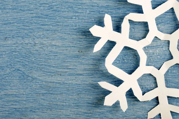 kısmi görünüm, mavi ahşap masa yüzeyinde origami kağıt kar tanesi kırpılmış parçası 