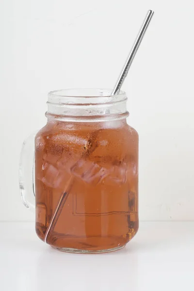 玻璃罐中装有冰块和金属吸管的冰茶饮料 — 图库照片