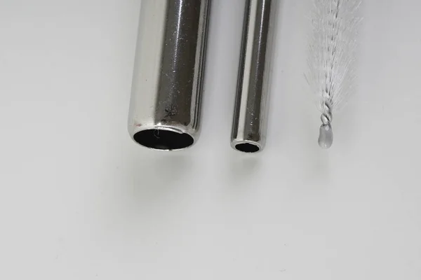 stainless steel tube straw and cleaning brush on white surface