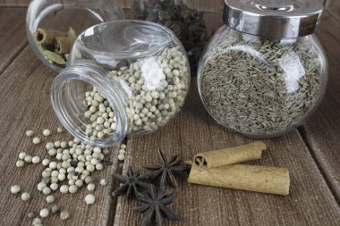 Yıldız anason ve ahşap masa, yuvarlak cam kavanoz üzerinde tohumlar 