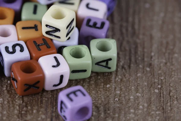 Muitas Contas Pequenas Coloridas Bagunçadas Com Letras Alfabeto — Fotografia de Stock