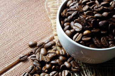 beyaz kahve fincanı ve aromatik kavrulmuş kahve çekirdekleri