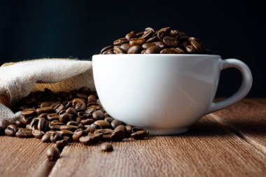beyaz kahve fincanı ve aromatik kavrulmuş kahve çekirdekleri