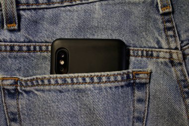Kot pantolonun arka cebinde akıllı telefon