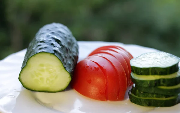 新鲜切片的黄瓜和番茄在厨房的一个夏天花园的背景 — 图库照片