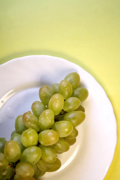 Grappe Raisins Verts Dans Une Assiette Blanche Sur Fond Jaune — Photo