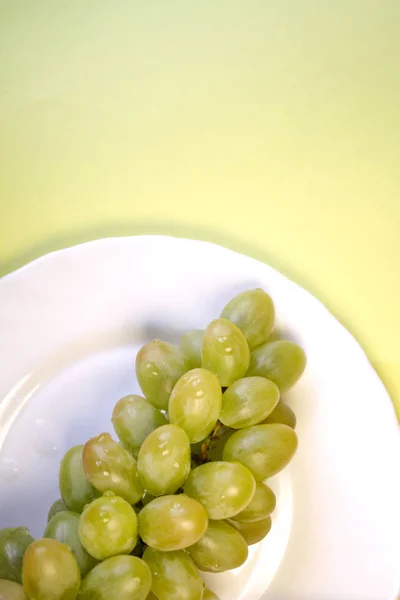 Grappe Raisins Verts Dans Une Assiette Blanche Sur Fond Jaune — Photo