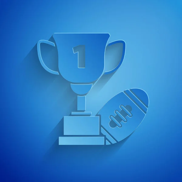 Papír vágott díj kupa és amerikai futball-labda ikon izolált kék háttér. Győztes trófea szimbólum. Bajnokság vagy verseny trófeát. Papírművészeti stílus. Vektoros illusztráció — Stock Vector