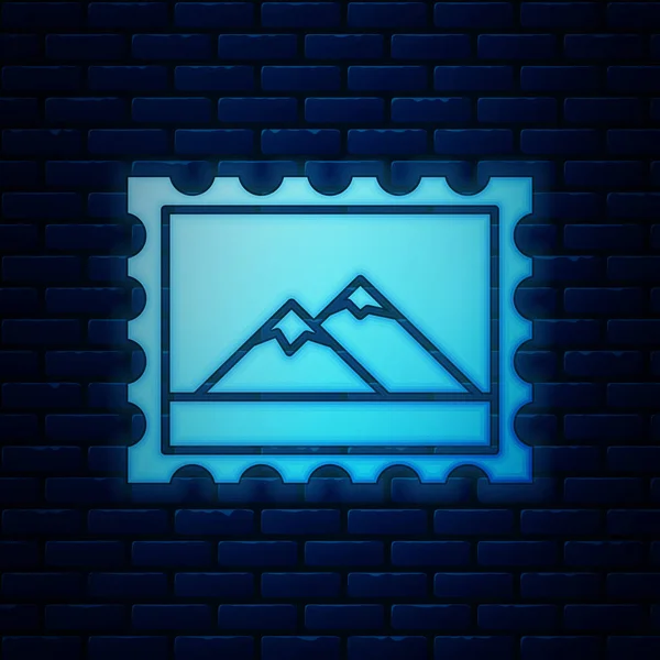 Leuchtende Neon-Briefmarke und Berge-Ikone isoliert auf Backsteinmauer Hintergrund. Vektorillustration — Stockvektor