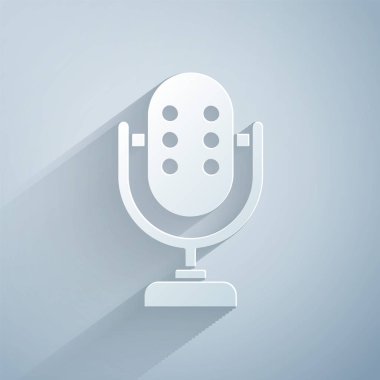 Kağıt kesiği mikrofon simgesi gri arkaplanda izole edildi. Radyodaki mikrofondan. Sözcü işareti. Kağıt sanatı tarzı. Vektör.