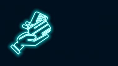 Siyah arka planda izole edilmiş kredi kartı ikonu olan parlayan neon hattı insan eli. Çevrimiçi ödeme. Kartla öde. Finansal operasyonlar. 4K Video hareketli grafik canlandırması