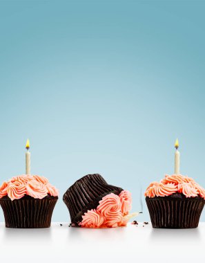 Bir sıra kekin içinde, üzerinde mumlar olan küçük kekler ezildi.