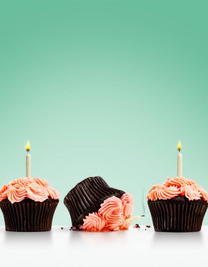 Kek sırasına dizilmiş keklerin üzerinde mumlar ve yeşil taşralılar vardı.