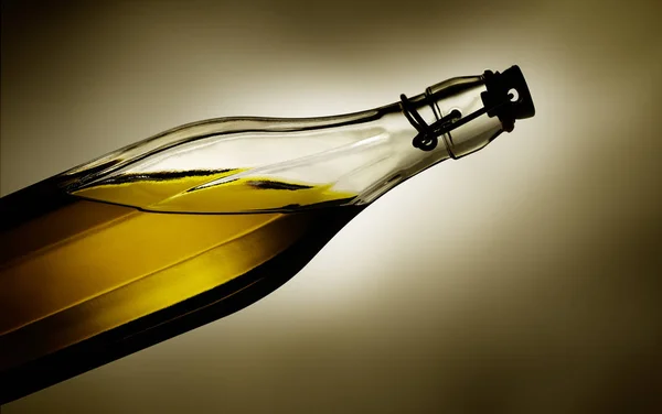 Драматический свет светится через оливковое масло в прозрачной стеклянной бутылке — стоковое фото