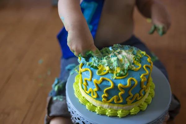 First birthday cake smash with finger poking into cake