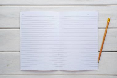 Açık kitap, orta sayfa ve kalem Beyaz ahşap bir masa üzerinde