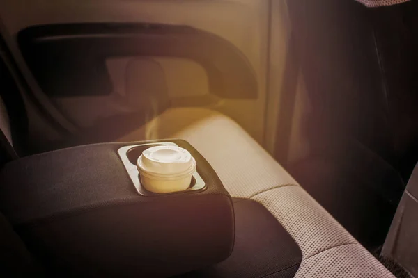 Concept paper hot cup of coffee in the cup holder in the car.