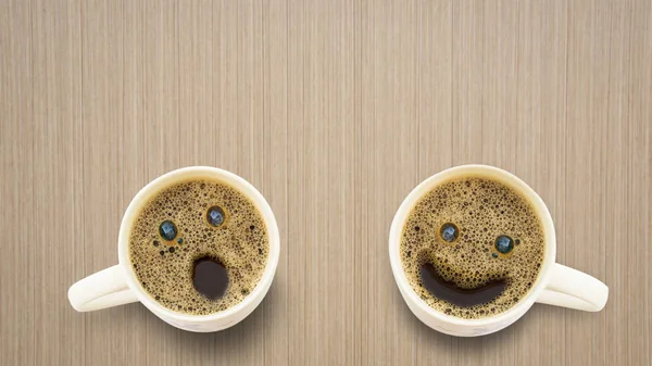 Three different faces coffee cup on a wooden table.