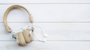 konsept üst görünümü, beyaz ahşap bir masa üzerinde iki kulaklık