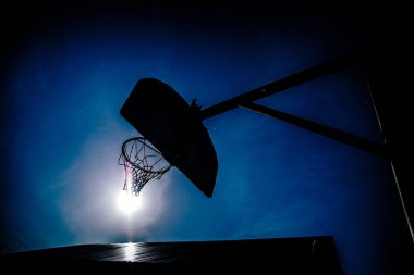 Mavi gökyüzünün arka planında basketbol potası