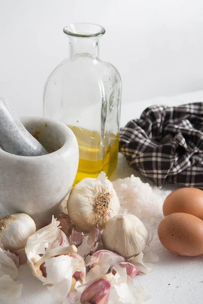 Garlic, oil and eggs for mayonnaise in a kitchen