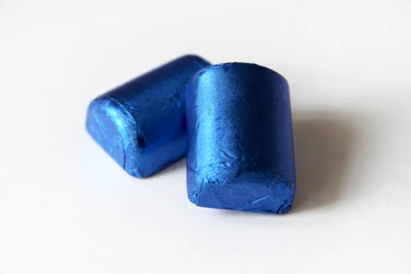 흰색 표면에 분리된 파란색 호일에 싸인 초콜릿 캔디 더미와 텍스트용 복사 공간 — 스톡 사진
