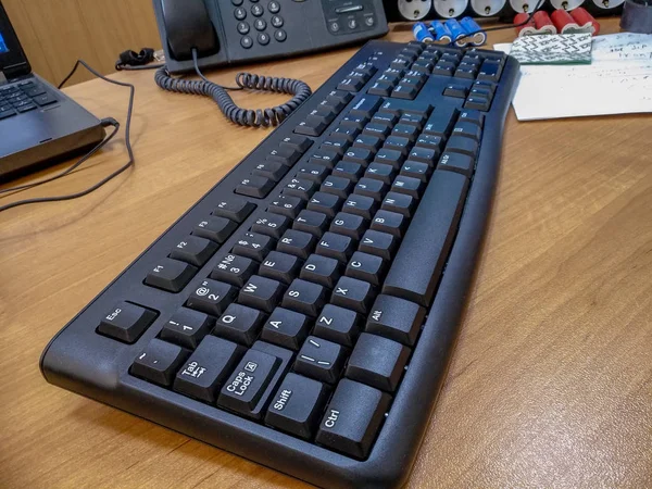 Mesa de oficina con teclado con cable de ordenador negro. Primer plano. . — Foto de Stock