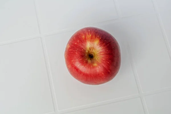 Червоне яблуко ізольовано на білому столі. З відсічним контуром . — стокове фото