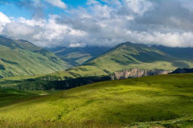 Yaz aylarında mavi gökyüzü ve bulutlar ile güzel bir güneşli bir günde çiçek açan çayır ve dağlar ile pastoral alp dağ sahne güzel görünümü.